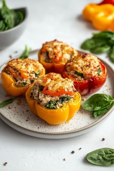 four stuffed peppers on a plate with basil