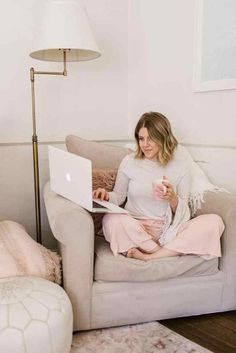 a woman sitting on a couch using her laptop