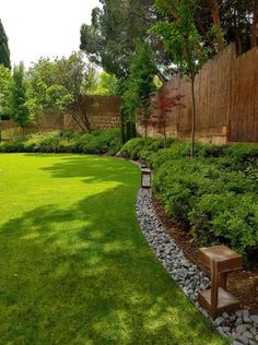 a garden with green grass and rocks in the middle