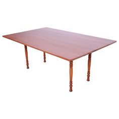 a wooden table with two turned legs and a square top, on an isolated white background