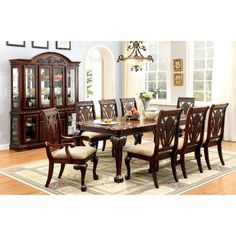 a dining room table with chairs and china cabinet in the corner, along with an area rug on the floor