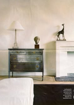 a living room with a fireplace and a giraffe statue on top of it