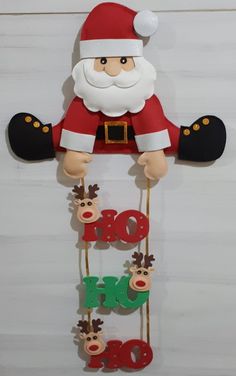 a santa clause hanging from the side of a wall with letters and reindeers on it