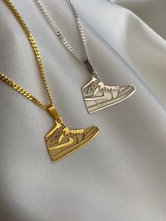 two gold and silver necklaces with sneakers on them