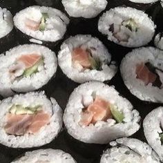 sushi rolls with salmon and avocado on them are ready to be eaten