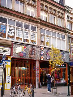 a man standing in front of a building with lots of signs on the side of it