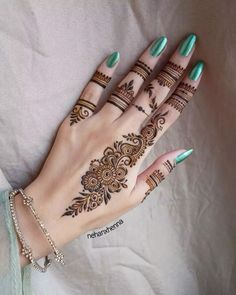 a woman's hand with henna tattoos on it