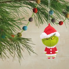 a christmas ornament hanging from a pine tree with the grin face on it