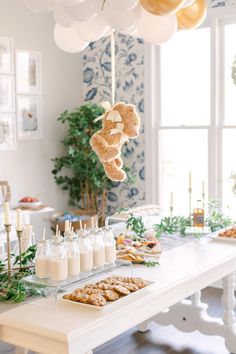 a table topped with lots of desserts and balloons in the shape of teddy bears