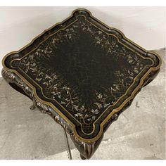 an ornately decorated coffee table with metal legs