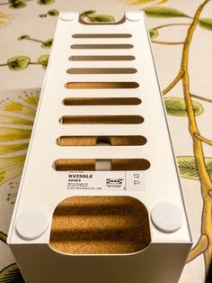 a close up of a white box with holes in it on a floral table cloth