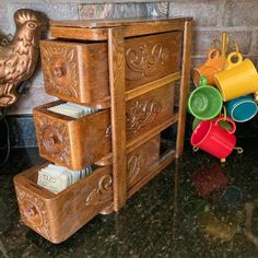 an old wooden dresser with cups and mugs on the top shelf next to it