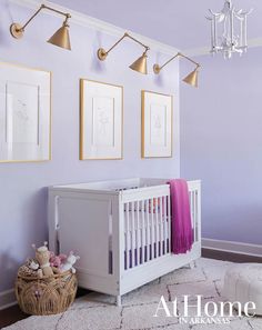 a baby's room with purple walls and pictures on the wall