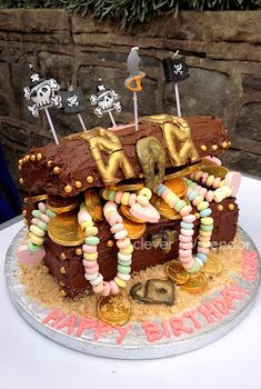 a birthday cake made to look like a house with lots of gold coins and decorations