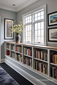 there is a vase with flowers in it on the bookshelf next to the window