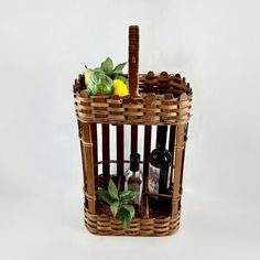 a wine bottle holder made out of wicker with lemons and bottles in it