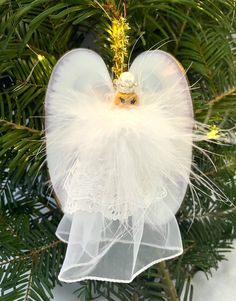 an angel ornament hanging from a christmas tree