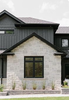 the front of a house with black trim and windows