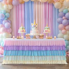 a table topped with cake and balloons in the shape of unicorn's head on top of it