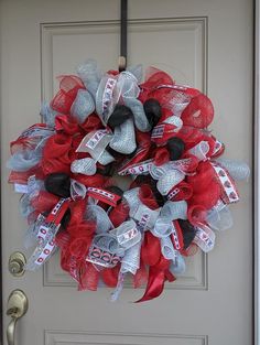 a red and grey mesh wreath with ribbons on the front door to celebrate someone's 90th birthday