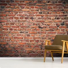 a chair sitting in front of a brick wall with a wooden frame on the floor