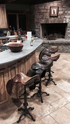 several chairs are lined up in front of an island with a stone fireplace behind it