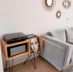 a living room with a couch, table and television on it's stand in front of a mirror