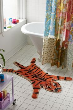 a bathroom with a rug that looks like a tiger laying on the floor next to a bathtub