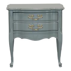 a blue dresser with two drawers and gold trimmings on the top, against a white background