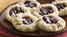 small pastries are sitting on a wooden plate