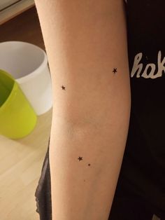 a woman's arm with small stars on it