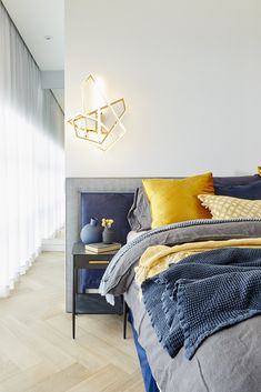 a bed with blue and yellow pillows on top of it