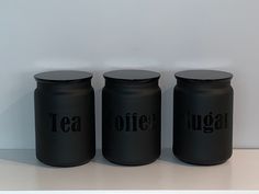 three black jars with the words tea, coffee and sugar on them