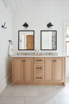 a bathroom with two sinks and mirrors on the wall