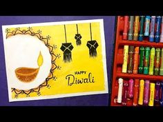 some crayons are next to a card with an image of diwali