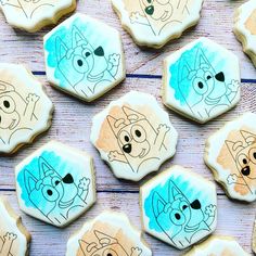 decorated cookies with cartoon characters on them sitting on a wooden table next to each other