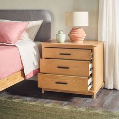 a bedroom with a bed, two nightstands and a lamp on top of it