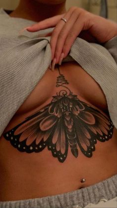 a woman with a butterfly tattoo on her stomach