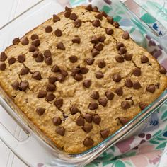 a glass baking dish filled with oatmeal and chocolate chip toppings on a floral table cloth