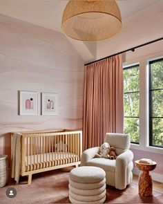 a baby's room with pink walls and furniture