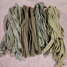 several pieces of cloth are laid out on the floor, one is green and the other is beige