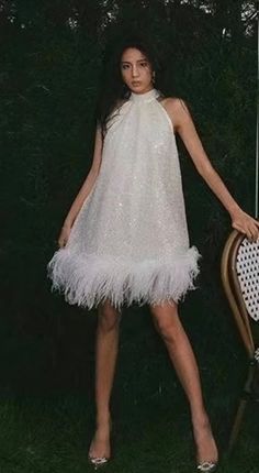 "Beautiful sequin and pearl A line mini dress with ostrich feather trim. Mock neck with back tie. Oversized fit. 3 layers of ostrich feather trim.  One size- fits up to a 50\" Bust  Length approx 27\" * Sizing - All items are made according to measurement ranges, they are NOT typical letter or numeric sizing. It is imperative to compare your exact measurements with the size chart provided either in the listing photos or item descriptions and to also add your measurements under Personalization. I White Feather Dress, A Line Mini Dress, Ostrich Feather Trim, Feather Jacket, White Halter Dress, Feather Tops, Pearl Dress, Feather Trim, Ostrich Feather