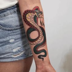 a woman's arm with a snake tattoo on it