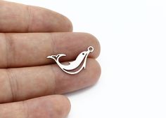 a person holding a tiny bird charm in their hand