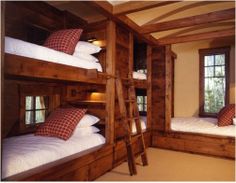 there are bunk beds with pillows on them in the room that is made out of wood