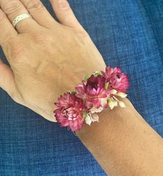 a woman's hand wearing a bracelet with flowers on it