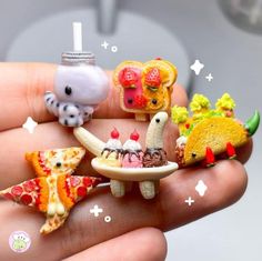 a hand holding several miniature food items in it's palm, including pizzas and mice