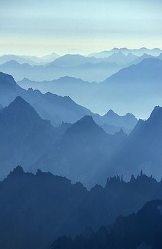 the mountains are covered in blue haze as seen from an airplane