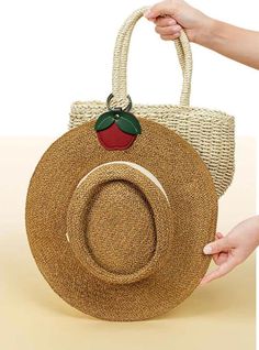 a straw bag with an apple on the front and a straw hat on the back