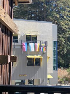 an apartment building with colorful clothes hanging out to dry on the balcony and in between two balconies